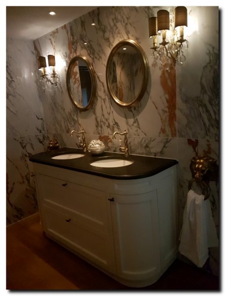 twee-ovale-spiegels-in-badkamer-op-marmer-muur-ova